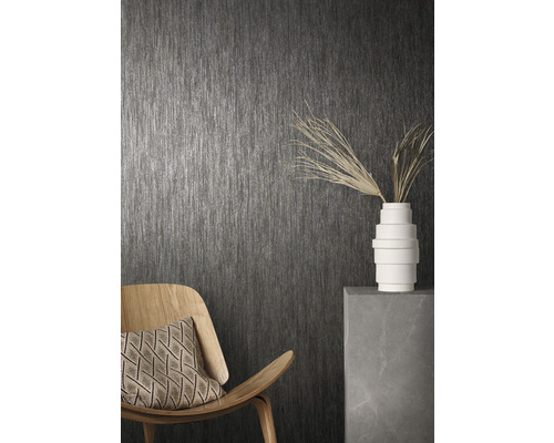 Raumansicht mit grauer Tapete, Holzstuhl, Kissen und Dekoration