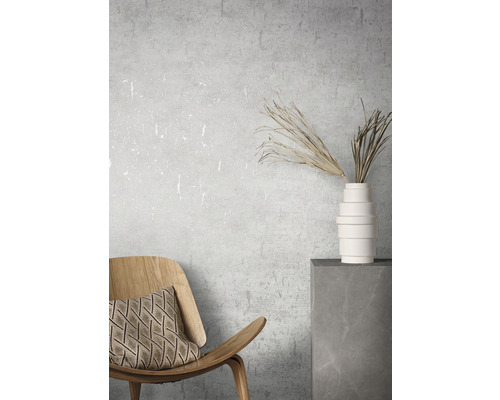 Dekoratives Interieur mit Holzstuhl, Kissen, Vase und Trockenblumen auf einem Sockel.