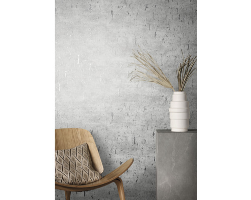 Zimmeransicht mit Stuhl, Kissen, Vase und Dekorationsgräsern vor einer Wandtapete