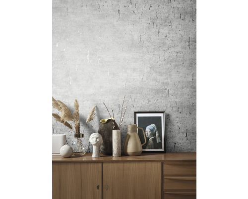 Wohnraum mit gemusterter Tapete und dekorativen Elementen auf einem Holzschrank