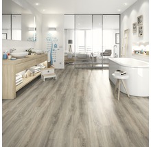 Helles Badezimmer mit Waschtisch, Badewanne und Laminatboden in Holzoptik