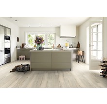 Helle, moderne Küche mit Kücheninsel, Holzboden, Blumenstrauß und verschiedenen Küchenutensilien.