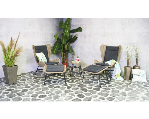 Szene mit zwei Korbsesseln, Fußhockern und Beistelltisch auf Steinterrasse