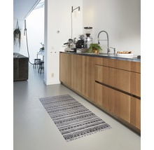 Küche mit Holzschränken und einem gemusterten Teppich