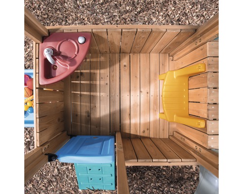Innenansicht eines Spielhauses mit Spüle, Tisch und Aufbewahrungsbox aus Holz und Kunststoff