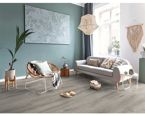 Heller Wohnraum mit Sofa, Sessel, Dekoration und grauem Bodenbelag