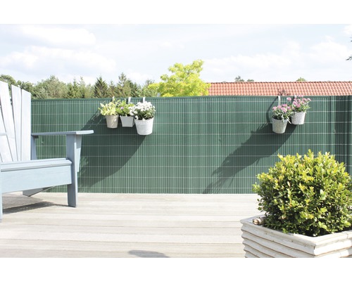 Sichtschutzzaun mit bepflanzten Hängetöpfen auf einer Terrasse