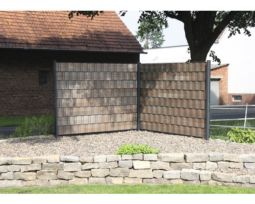 Sichtschutzzaun mit schindelartiger Oberfläche im Garten