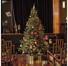 Festlich geschmückter Weihnachtsbaum mit Geschenken in einem Raum mit Bühnenbild