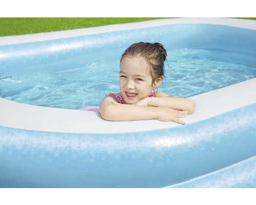 Mädchen im aufblasbaren Schwimmbecken im Garten