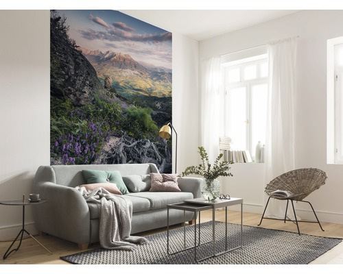 Helles Wohnzimmer mit Sofa, Teppich und Fototapete mit Bergmotiv