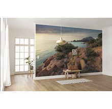 Wandgestaltung mit Fototapete einer Küstenlandschaft in einem hellen Raum.