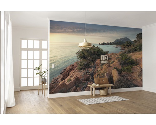 Wandgestaltung mit Fototapete einer Küstenlandschaft in einem hellen Raum.