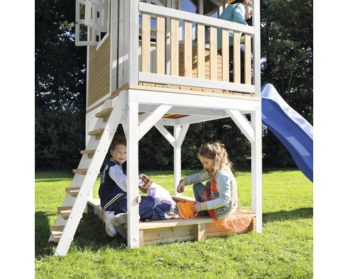 Spielturm mit Rutsche und Sandkasten mit spielenden Kindern im Garten.