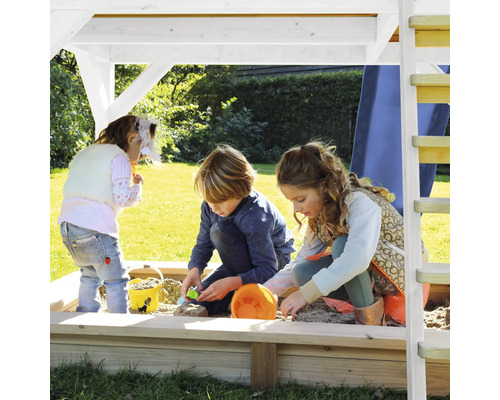 Kinder spielen im Sandkasten mit Dach auf einem Spielplatz.