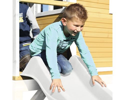 Junge rutscht auf einer Rutsche eines Spielhauses