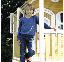 Junge steht vor einem Holzspielhaus mit geöffneten Fenstern