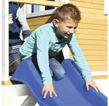 Junge rutscht auf einer blauen Rutsche an einem Spielhaus