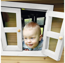 Kleiner Junge schaut aus dem Fenster eines Spielhauses.