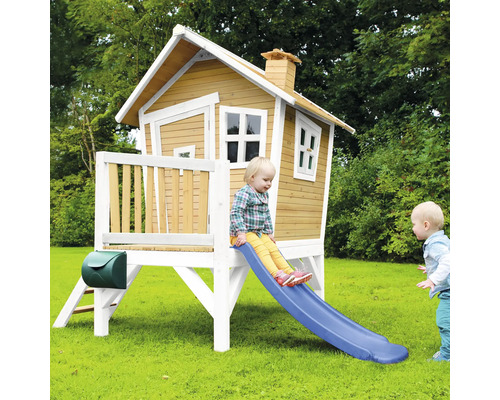 Kinderrutsche an einem erhöhten Holzspielhaus im Garten mit Briefkasten
