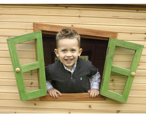 Junge schaut aus dem Fenster eines Holzspielhauses