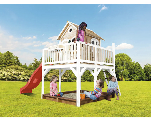 Spielhaus mit Rutsche, Sandkasten und Kindern auf einer Wiese.