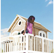 Mädchen mit Spielzeug-Fernglas auf dem Balkon eines Holz-Spielhauses im Garten