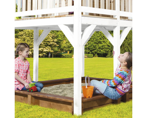 Zwei Kinder spielen in einem Sandkasten mit Überdachung in einem Garten.