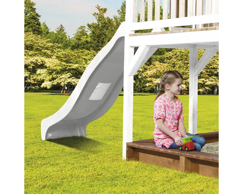 Kind auf einem Spielplatz mit Rutsche und Sandkasten