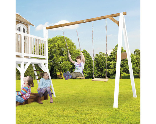Kinderschaukel mit Holzschaukeln auf einer Wiese mit spielenden Kindern