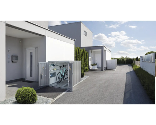 Fahrradbox vor einem Wohnhaus mit geöffneten Türen, in dem ein Fahrrad steht