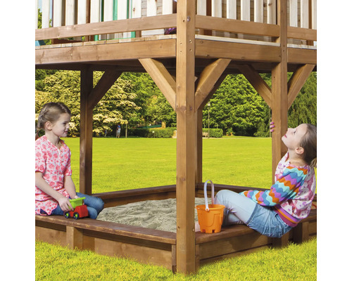 Sandkasten mit Holzrahmen und zwei spielenden Kindern im Garten