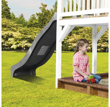 Spielturm mit Rutsche und Sandkasten im Garten mit spielendem Kind