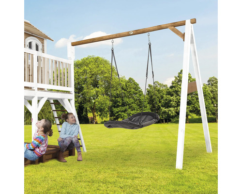 Kinderschaukel mit Nestschaukel an einem Holzspielturm im Garten.