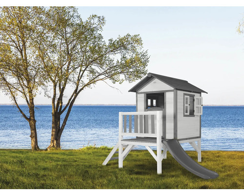 Spielhaus mit Rutsche auf einer Rasenfläche in Seenähe