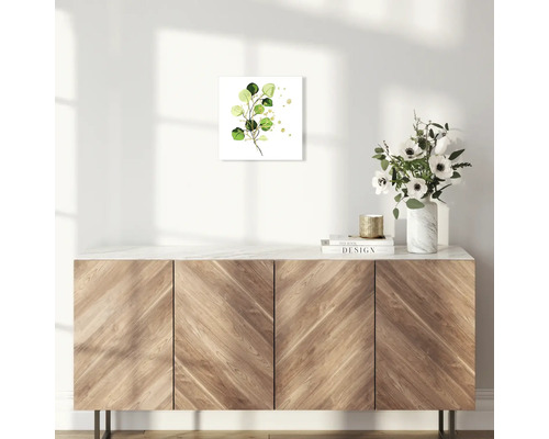 Dekoratives Wandbild mit Eukalyptusmotiv im Wohnraum auf einem Holzschrank