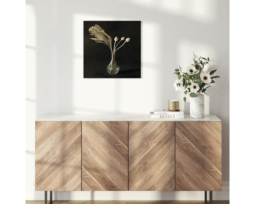Dekorative Wandkunst mit Blumenstillleben über einem Holzschrank
