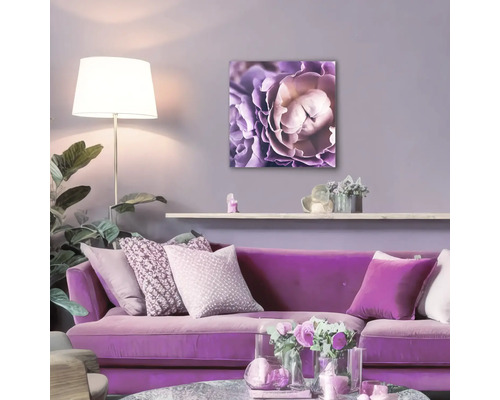 Wohnzimmer mit lila Sofa und Blumenbild an der Wand