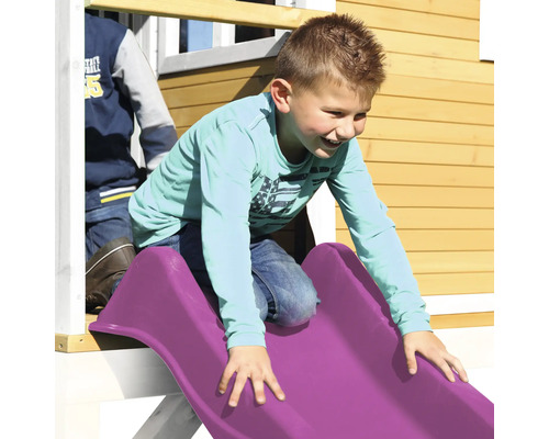 Junge rutscht auf einer Spielplatzrutsche aus Kunststoff