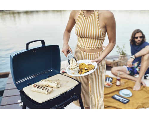 Person grillt Wraps auf einem tragbaren Gasgrill im Freien.