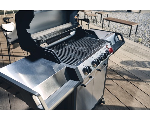Edelstahl Gasgrill mit Grillrost und Bedienelementen auf einer Terrasse.