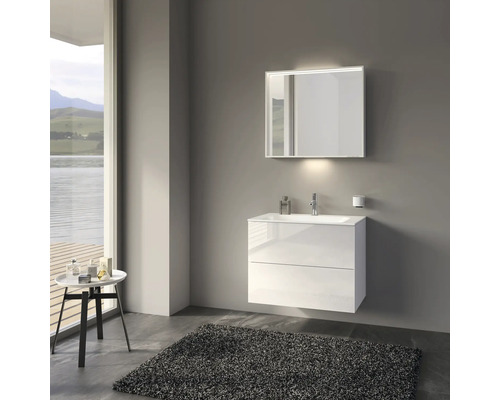 Modernes Badezimmer mit weißem Waschtisch, beleuchtetem Spiegel und Teppich