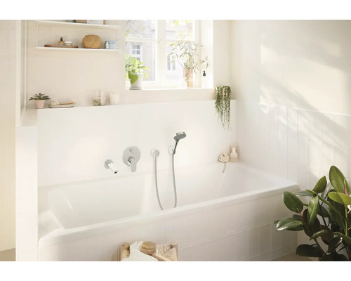 Helles Badezimmer mit Badewanne, Armatur und Pflanzen für eine entspannende Atmosphäre