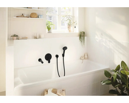 Badezimmer mit Badewanne und schwarzer Aufputz-Armatur