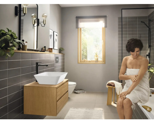 Badezimmer mit Waschtisch, Spiegel, Beleuchtung und Dusche