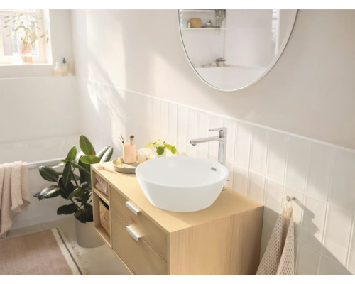 Helles Badezimmer mit Waschbecken auf Holzunterschrank, Armatur und Spiegel
