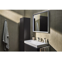 Badezimmer mit Waschbecken, Spiegel, Hochschrank und Handtüchern