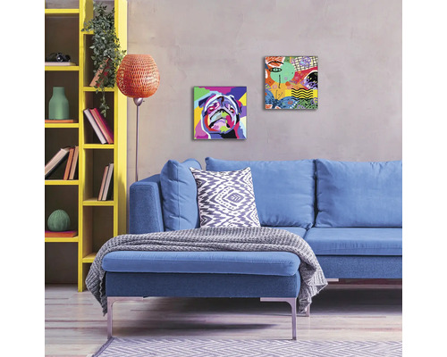 Wohnzimmer mit blauem Sofa, gelbem Regal und zwei abstrakten Gemälden