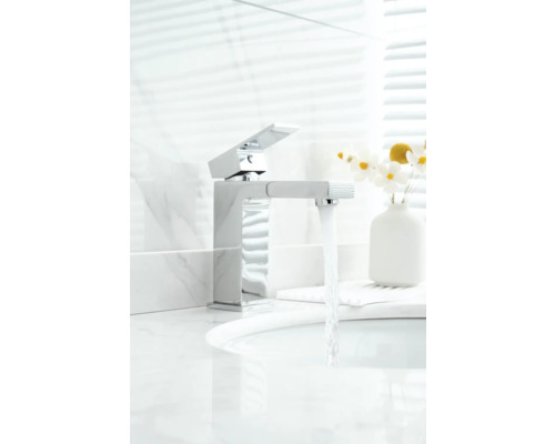 Moderner Wasserhahn aus Metall im Badezimmer mit fließendem Wasser.