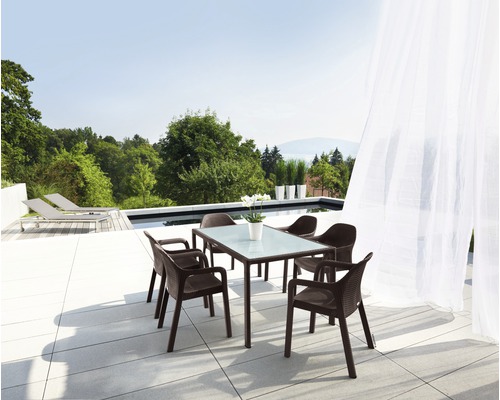 Gartenszene mit Esstisch und vier Stühlen auf einer Terrasse